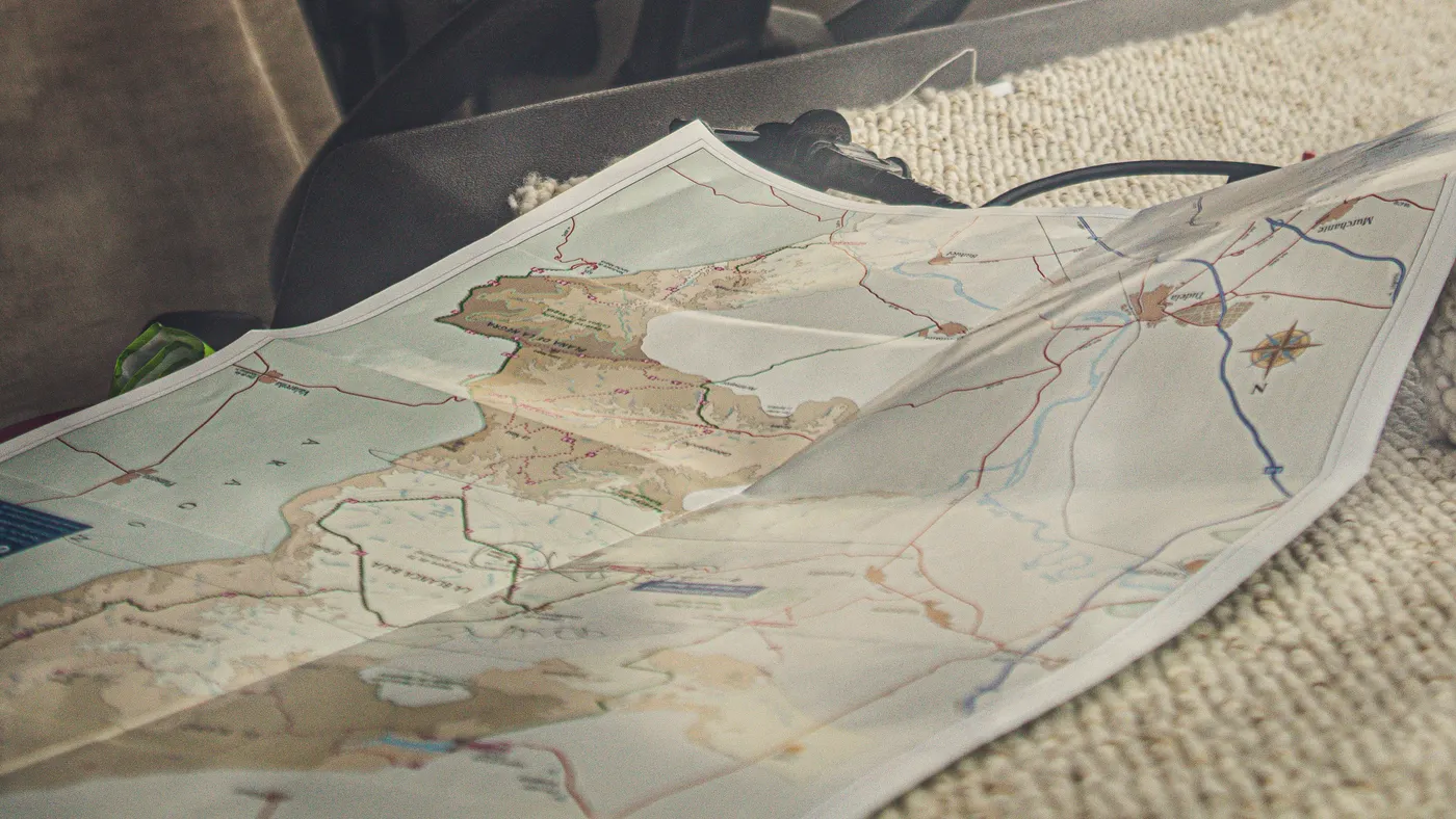 Planning a road-trip route with a paper map inside a car
